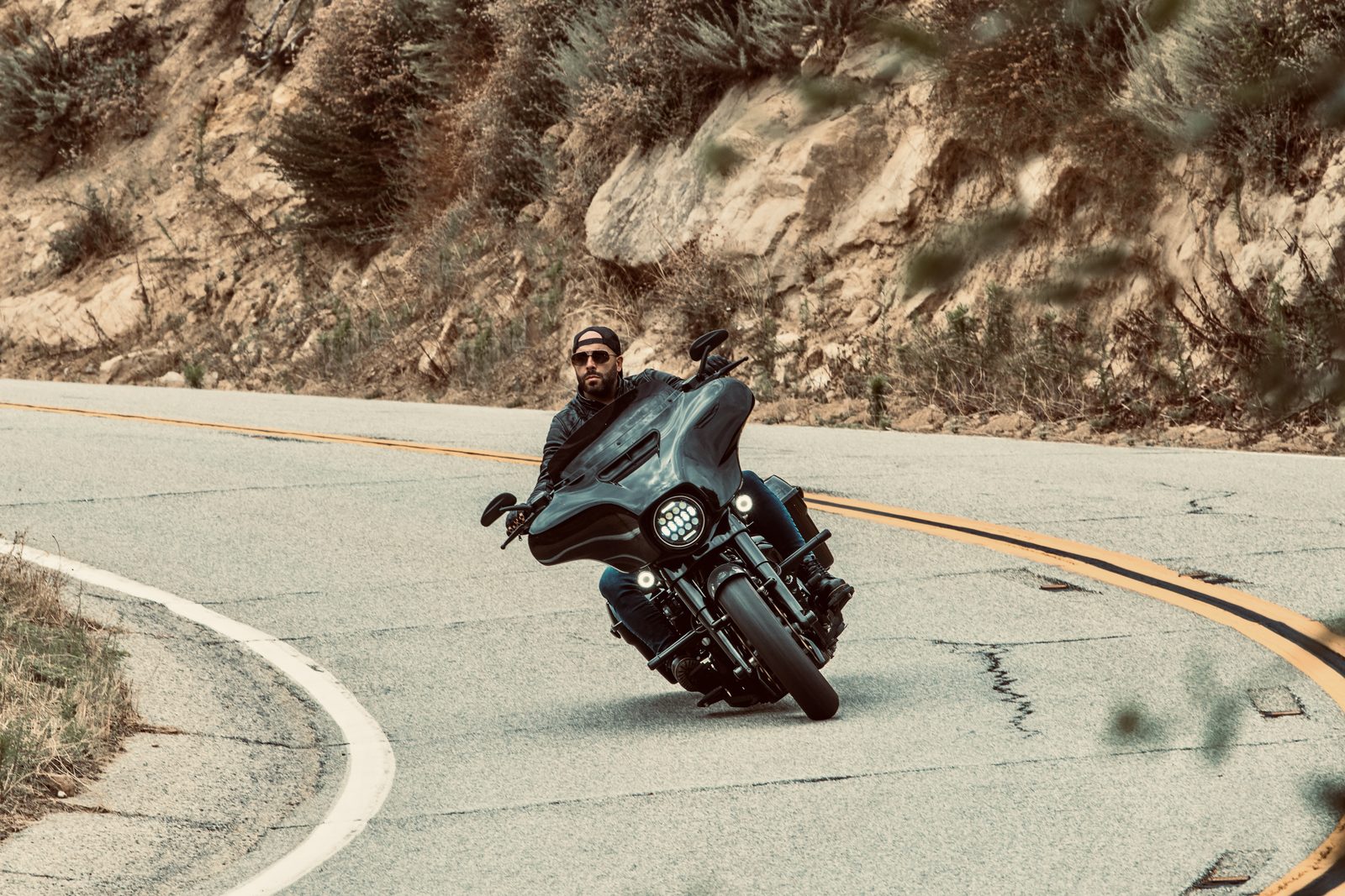 Roberto Valderrama leaning a black bagger into a canyon curve