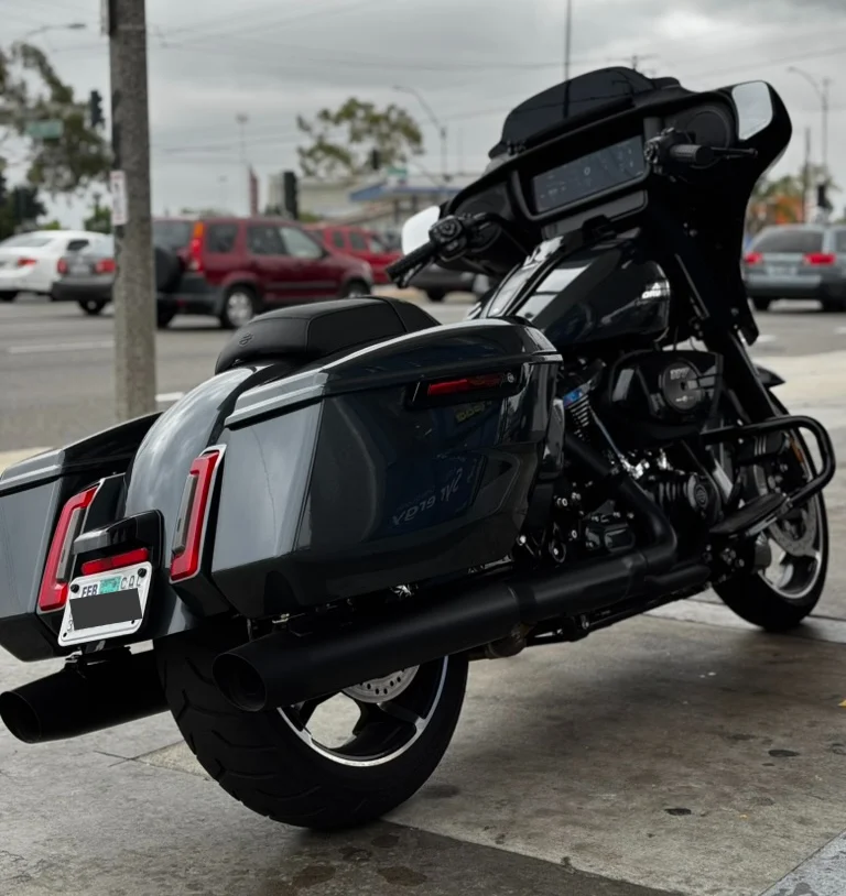 Rear-right angle at a gas stop—showcasing the contoured saddlebags, extended brake lights, and that massive infotainment screen glowing through the fairing. Iron Horse Metallic really pops under the canopy lights.