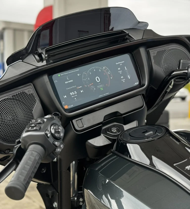 A rider’s view of the 12.3″ touchscreen tucked behind the fairing, the drawer release button—tech-forward, functional, and easy to access on the move.